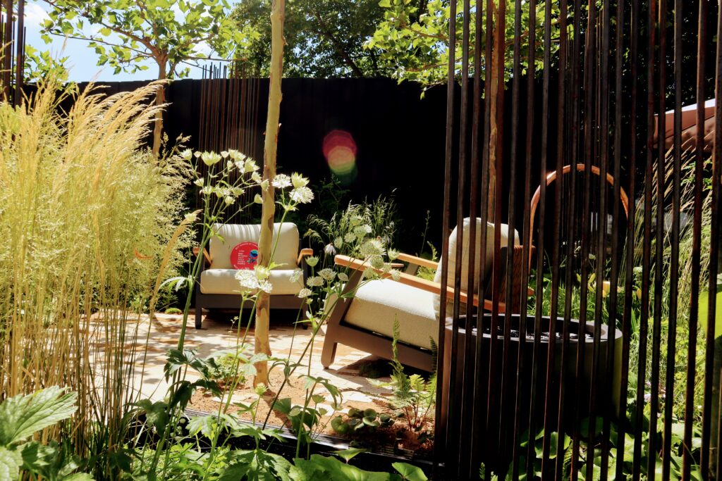 RHS Hampton Court show garden with layered planting and water feature
